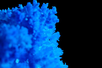 Macro image blue salt crystal on black background.
