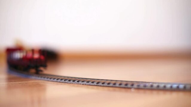 Freight train toy model moves by rails on circle.