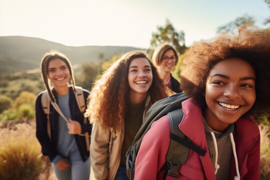 Four happy diverse female friends hiking in the mountains