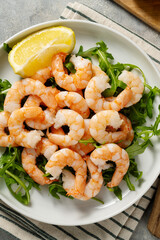 Cooked shrimps in a plate with lemon, seafood, bright background. 