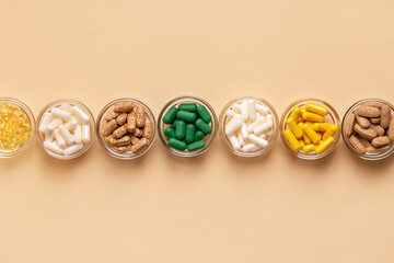 Tablets, capsules, pills, food supplements, minerals in small plates from above on a light beige background. Meds and vitamins to avoid illnesses to have a good health. Prevention of illness.