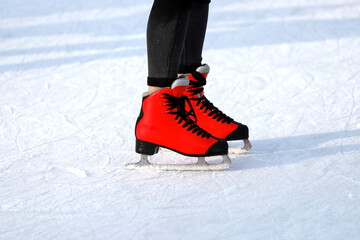 Naklejka premium Winter skating rink. Red skates skate on the ice. Active family sport during the winter holidays and cold season.