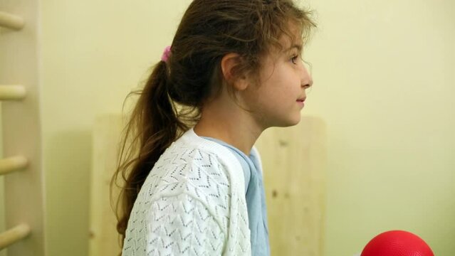 Little girl sits in profile on vibration platform
