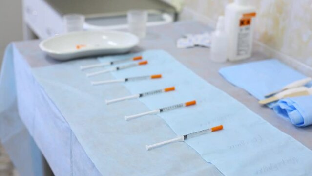 Hands of physician takes one syringes with medicines