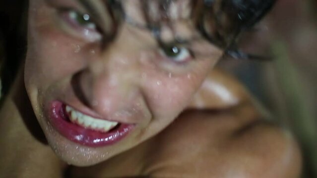 Intense sweaty face of muscular man pulling rope indoor