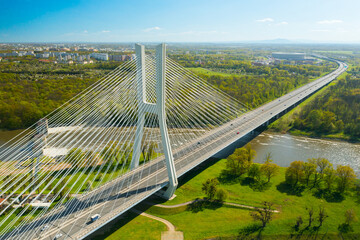 A lengthy pylon bridge extends across the Oder River, casting its shadow in the sunny city of...