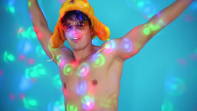 Half-naked handsome man in cap and glasses dances and sings