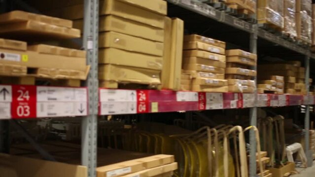 Many long shelves with cardboard boxes in warehouse