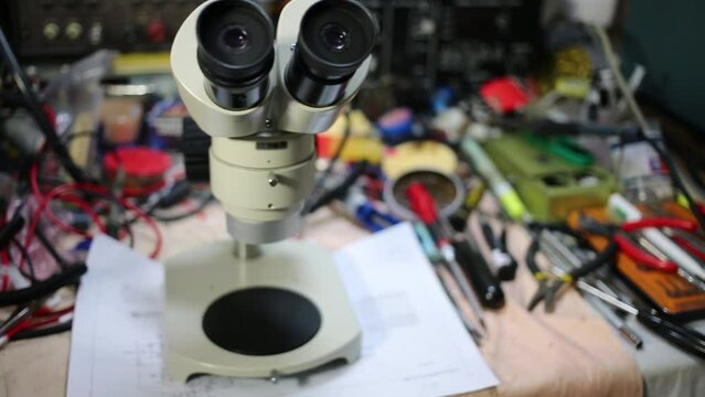 Microscope, many tools for repair of electronics on table