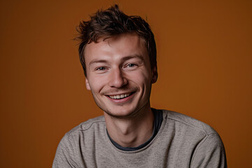 Fototapeta premium A man wearing a grey sweater smiles for the camera