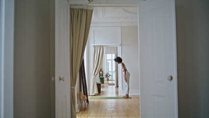 Yoga model training domestic interior. African girl doing flexibility exercises