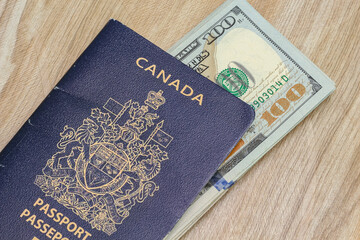Closeup view of canadian passport and us dollar banknotes.