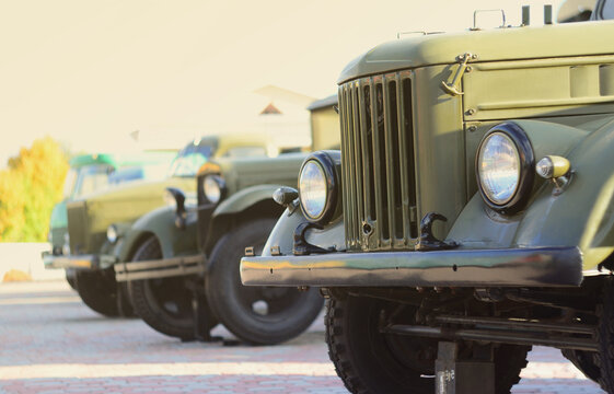 Photo of the cabins of three military off-road vehicles from the times of the Soviet Union. Side view of military cars from the front wheel
