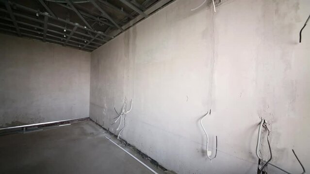 room with sticking out electric wires and mounted false ceiling.