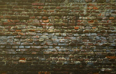 Very old damaged red brick wall with boneless bricks and cement mortar