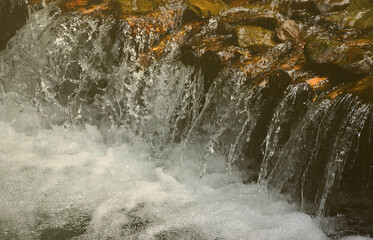 A small waterfall. The height difference of the water flow in the river is equipped with round...
