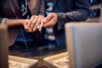Close up of couple buying engagement ring at jewelry store.