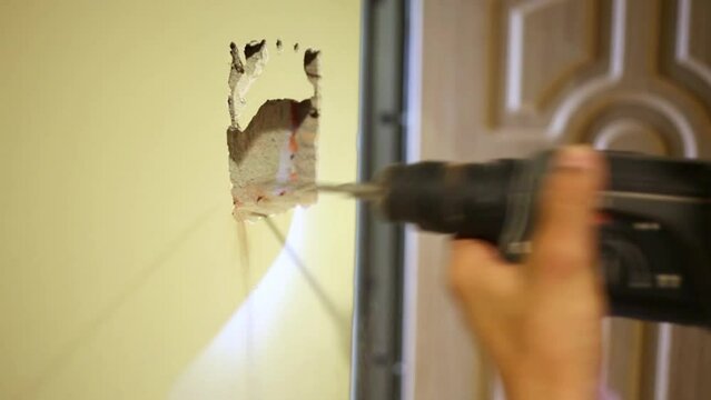 Worker makes quadrangular shape trench in wall 