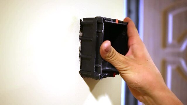 Worker tries on rectangular mounting box to hollow that 
