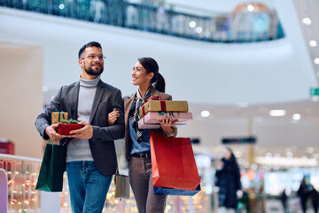 Happy woman and her boyfriend enjoy in shopping day in mall.