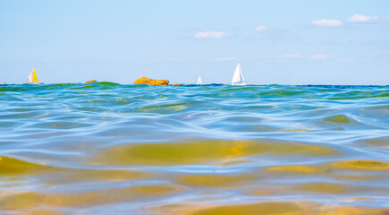 Sailing boats and waves seen by a swimmer at sea level, photography taken in Vendée