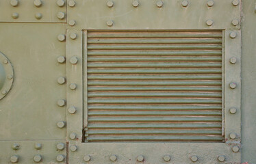 The texture of the wall of the tank, made of metal and reinforced with a multitude of bolts and...