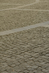 The texture of the paving slab (paving stones) of many small stones of a square shape under bright...
