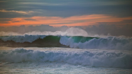 Ocean storm waves rolling to shore. Large powerful surf crashing at cloudy sky.