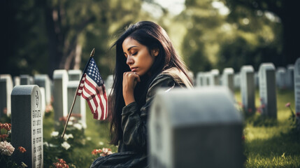 Woman praying in a memorial cemetery, for war soldiers - obrazy, fototapety, plakaty