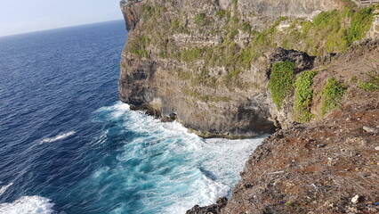 waves crash against a mountain cliff