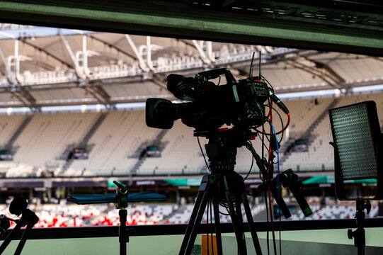 Telecast of professional athletics races. Media coverage of the Paris sporting event, modern athletics stadium in the background