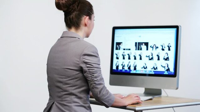 businesswoman sitting at desk and looking at computer screen