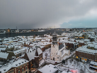 Aerial winter skyline panoramic view of Aalborg covered with snow. Old town with the Budolfi Church...