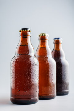 Beer bottle with drops on gray background.