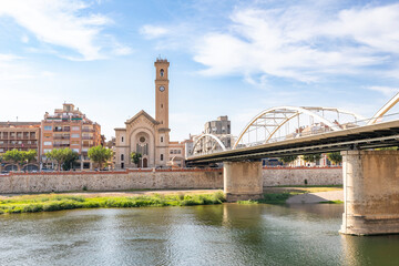 Obraz premium Church of Our Lady of the Rosary and the State bridge over Ebro river in Tortosa, comarca of Baix Ebre, Province of Tarragona, Catalonia, Spain