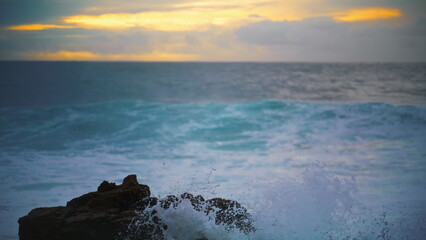 Obraz premium Ocean hitting coastline rock in early morning closeup. Beautiful evening seaside