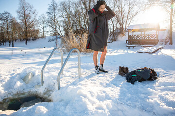 Man drying off  after cold winter swimming in the golden sunlight of a snowy landscape