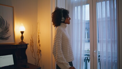 Happy model dancing in headphones indoors. Closeup african girl listening music