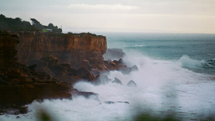 Fototapeta na wymiar Stormy ocean breaking cliffs in slow motion. Powerful waves crashing wild rocky