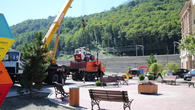 Loading of small tractor Bobcat to truck in Sochi. 
