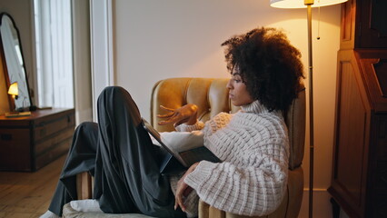 Calm girl swiping pad screen house. Curly brunette watching tab scrolling news