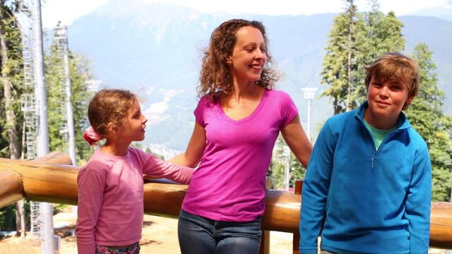 Mother and two children talk on viewing platform 