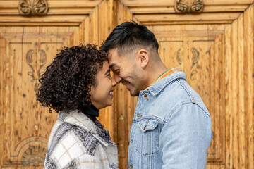 young couple with their heads resting on their foreheads looking into each other's eyes and smiling...