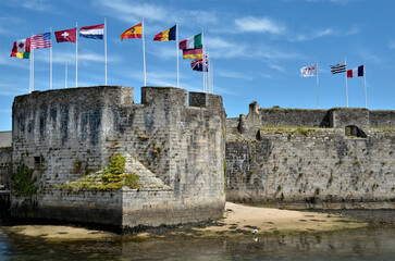 Ville Close (walled city) with many flags flying on the ramparts of Concarneau, a commune in the Finistère department of Brittany in north-western France