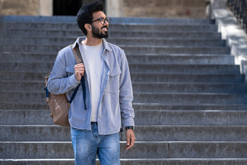 Fototapeta premium Young tall hindu man standing on the steps of an old building