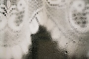 Abstraktes Motiv mit beschlagenem Fensterglas mit Eis- und Wassertropfenmuster vor alter weißer...