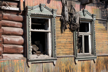 Fototapeta na wymiar A dilapidated wooden house with rickety walls and broken windows.
