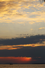 The ship sails against the backdrop of a red sunset and setting sun