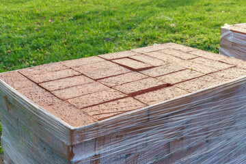 Laying paving slabs on a construction site. Repair of a road or sidewalk. The new paving slabs are neatly stacked in boxes.