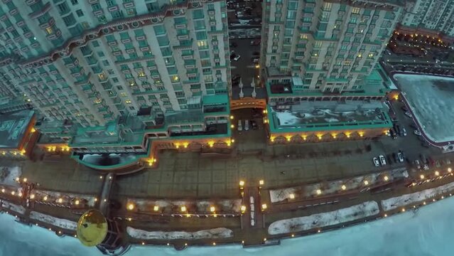 Illuminated quay near dwelling complex at winter evening